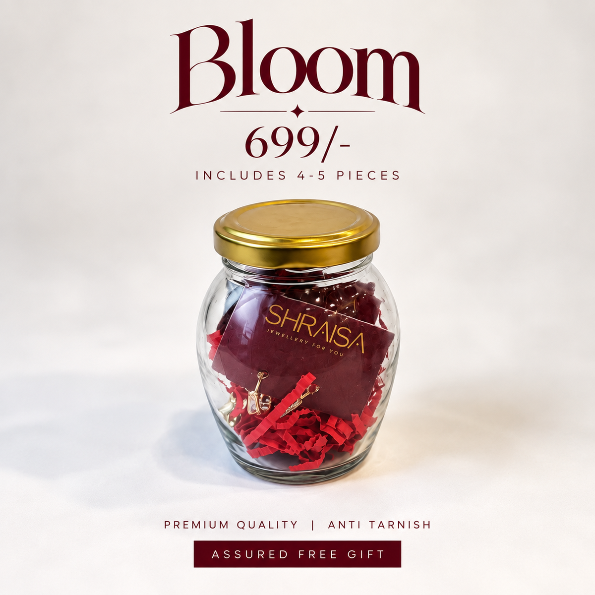 A glass jar with a gold lid containing deep red flowers and red paper filler, with text above reading 'Bloom 699/-' and 'INCLUDES 4-5 PIECES.' The jar label shows 'SHRAISA.